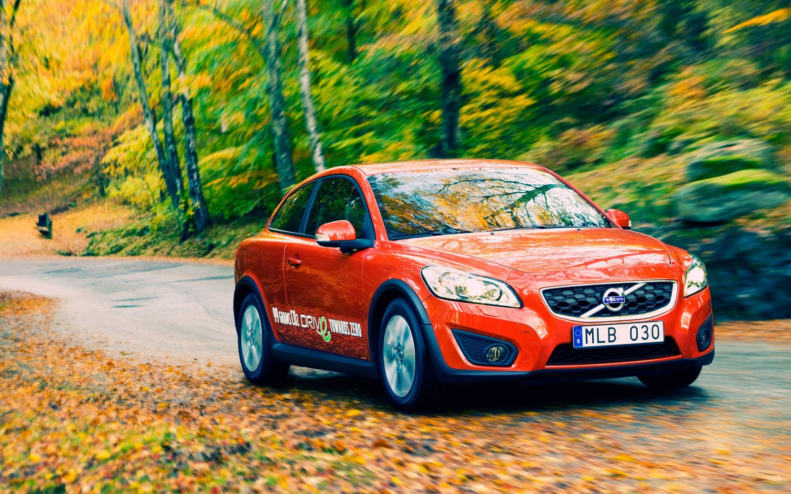 Beautiful Red Volvo in the Autumn Yellow Forest on the Road