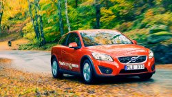 Beautiful Red Volvo in the Autumn Yellow Forest on the Road
