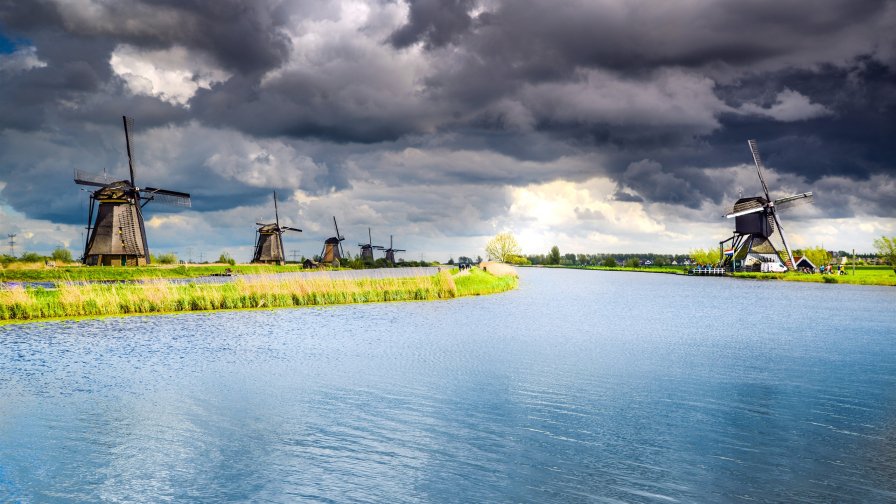 Clouds River Green Grass and Windmills