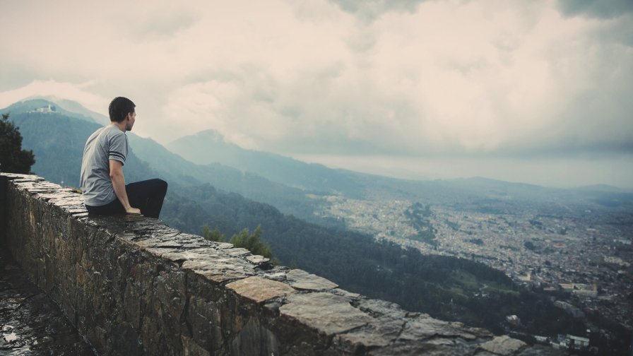 Men on Stone Fence and City in Valley